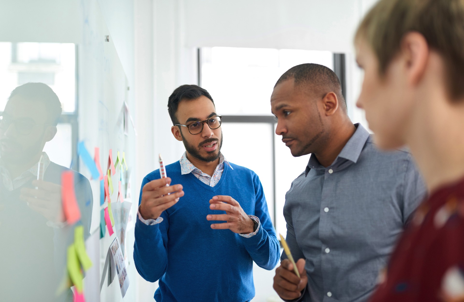 Portrait of an indian man in a diverse team of creative millennial coworkers in a startup brainstorming strategies